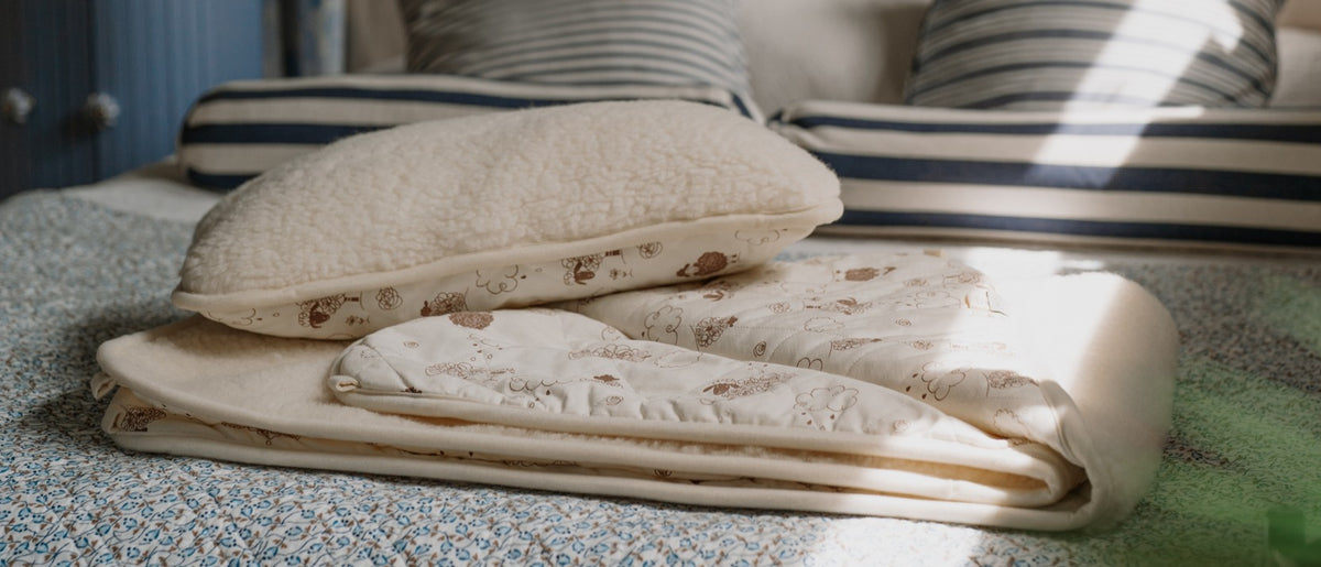 Surmatelas en laine plié et oreiller sur un lit