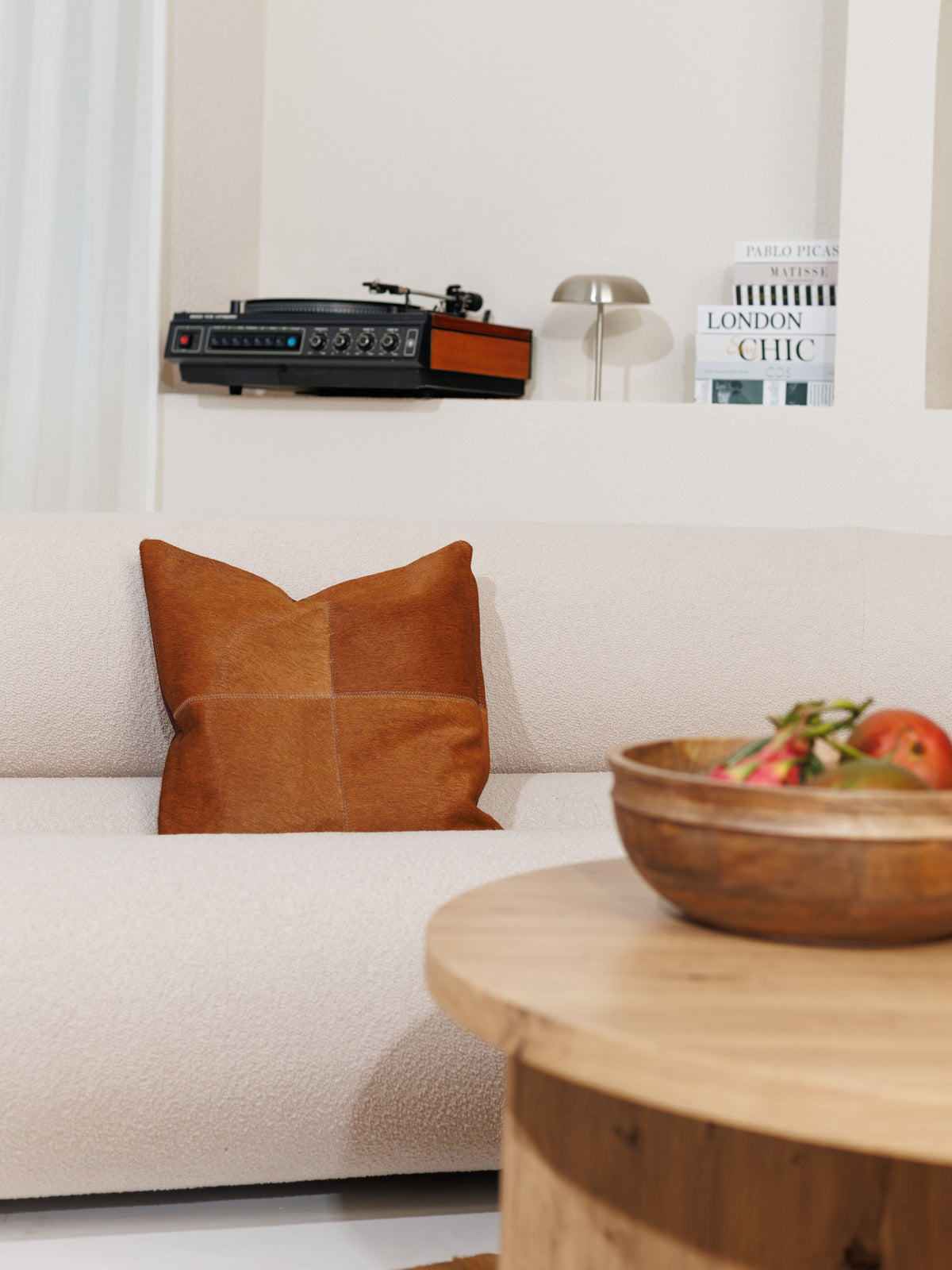 Housse de coussin en peau de vache caramel, ton plus soutenu, sur un canapé clair