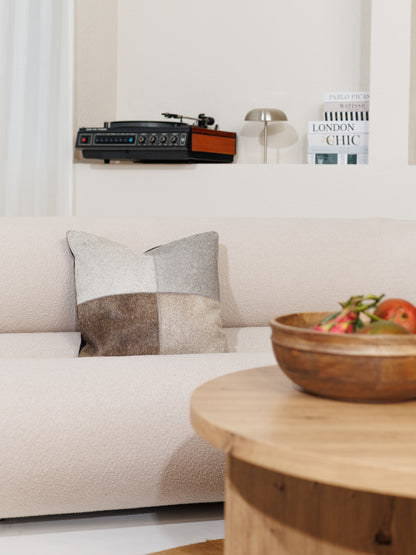 Housse de coussin en peau de vache grise sur un canapé clair